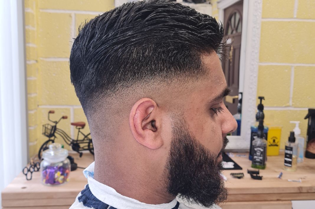 Textured top with mid fade and full beard